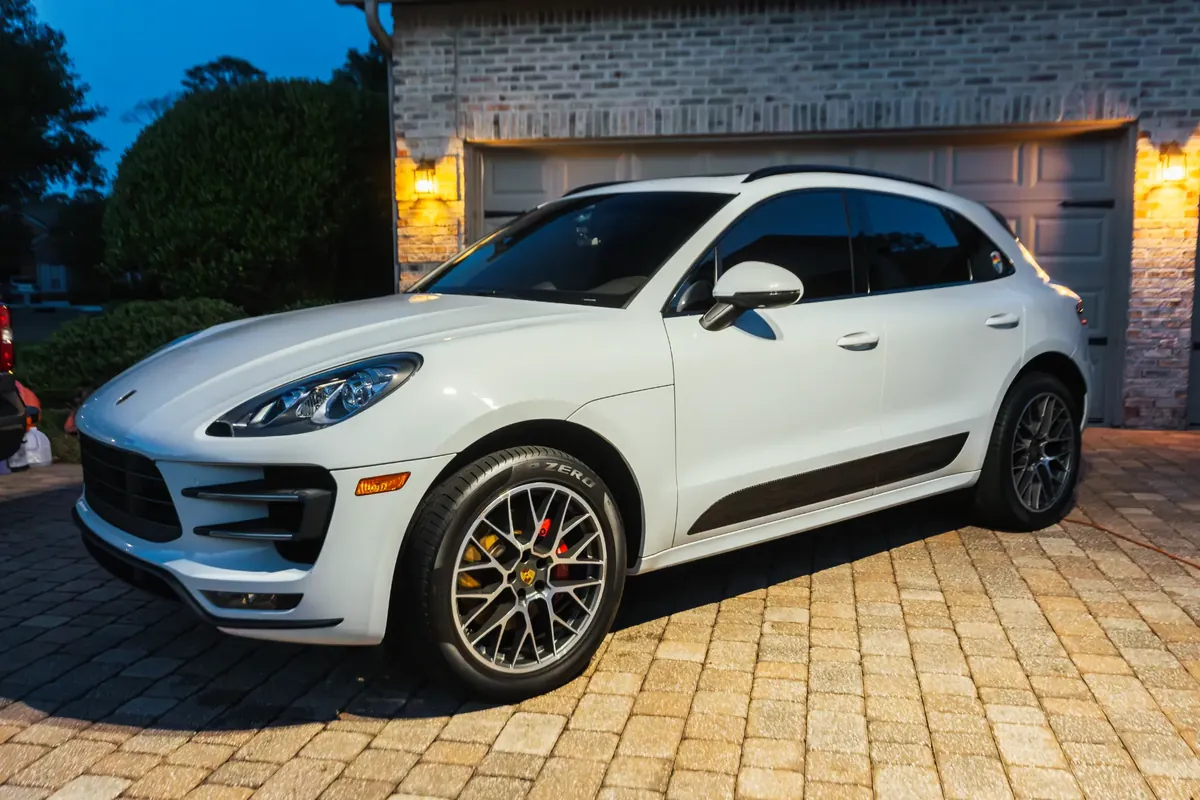 White Porsche Macan exterior with clean wheels and glossy paint after detailing