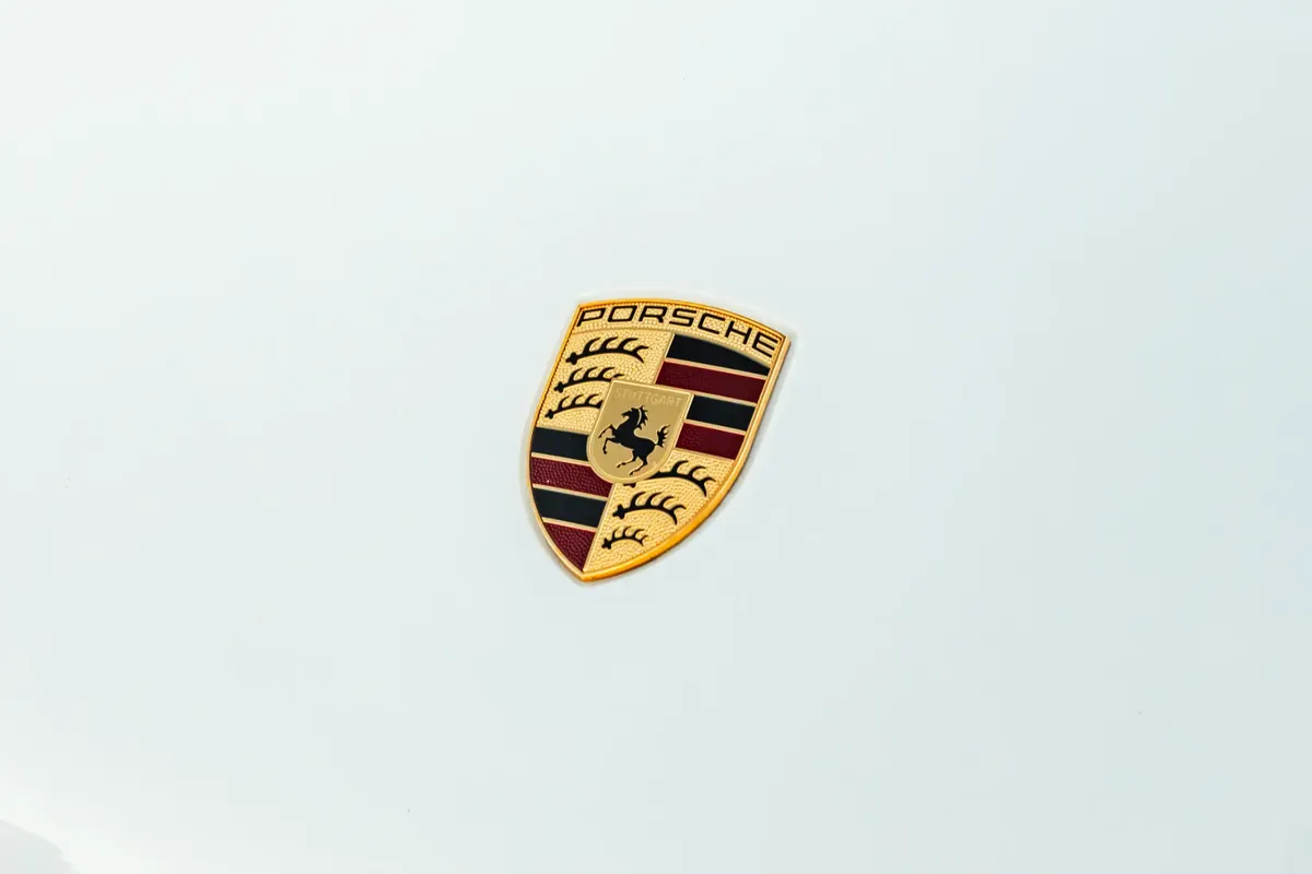 Pristine Porsche crest emblem on a clean white hood after detailing