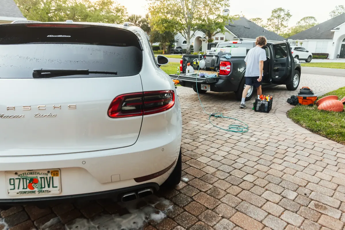 Porsche Macan alongside organized mobile detailing equipment